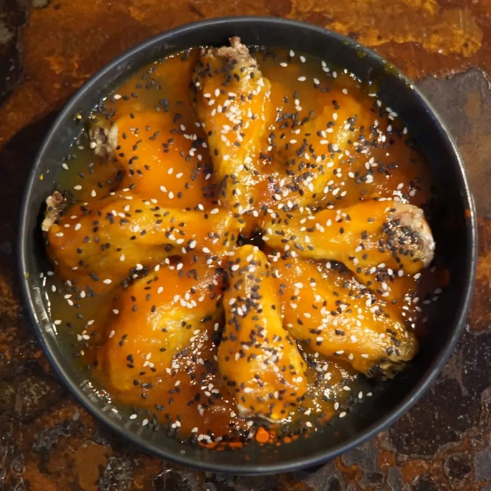 Alitas de pollo bañadas en salsa con semillas de sésamo